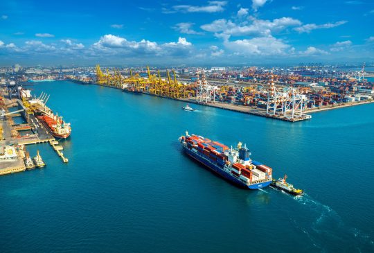 Aerial view of cargo ship and cargo container in harbor.